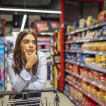 Woman buy products with her trolley at supermarket.